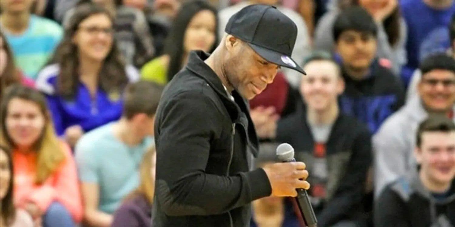 Just Isaac speaking to a gym full of students